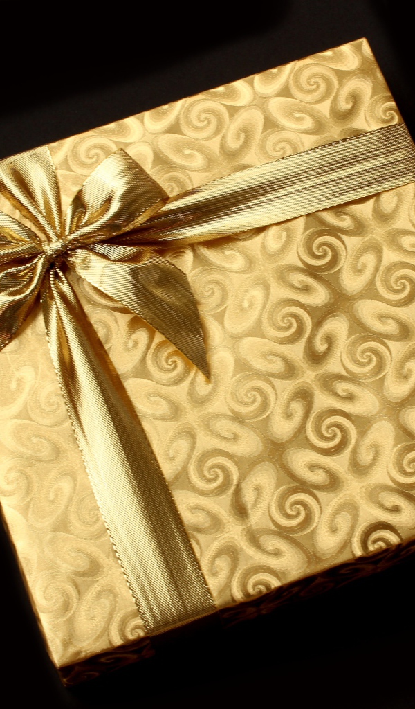 Золотая упаковка с подарком на черном фоне