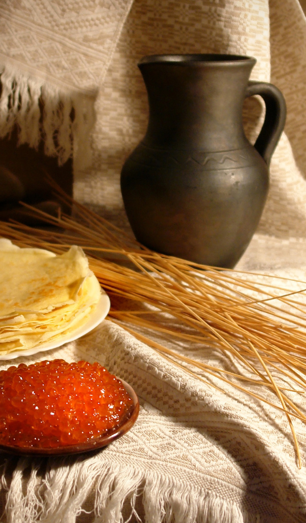 Блины с икрой на столе с колосьями на праздник Масленица