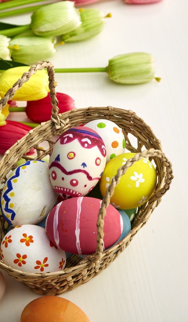 Корзина крашеных яиц с букетом тюльпанов