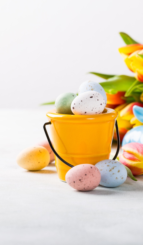 Букет тюльпанов на белом фоне с крашеными яйцами на Пасху