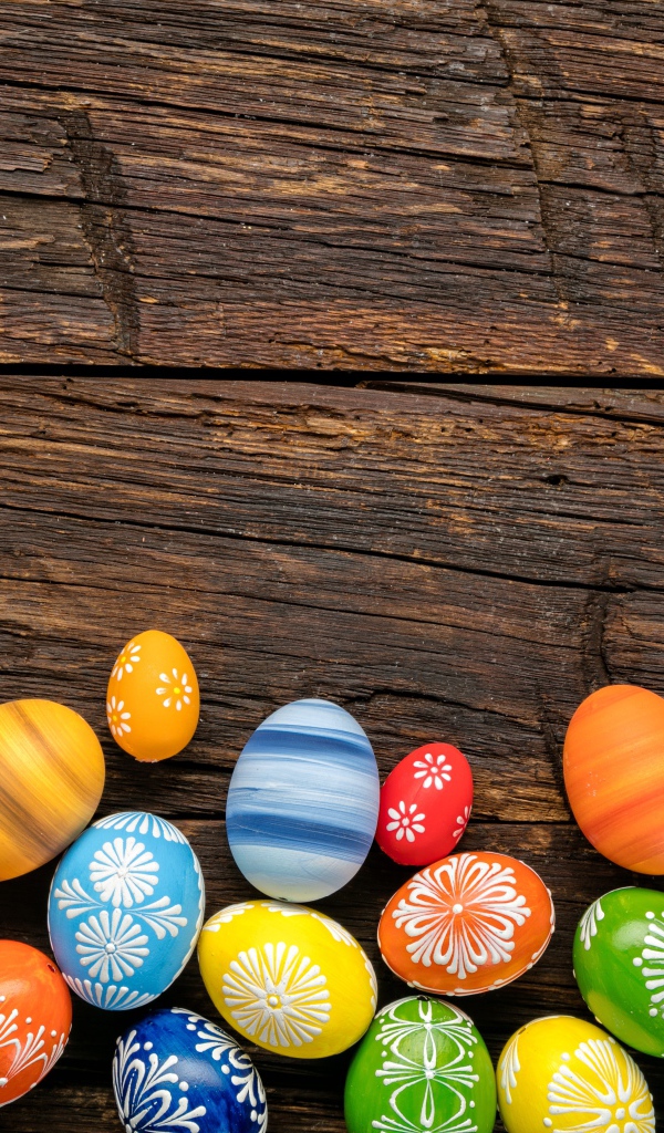 Разноцветные пасхальные яйца на деревянном столе