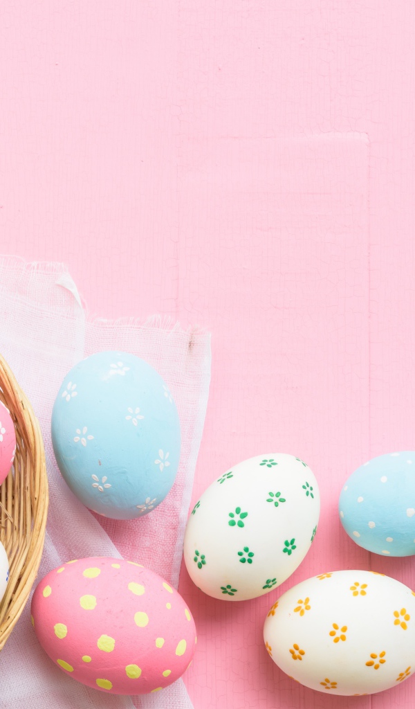 Разноцветные пасхальные яйца на розовом фоне