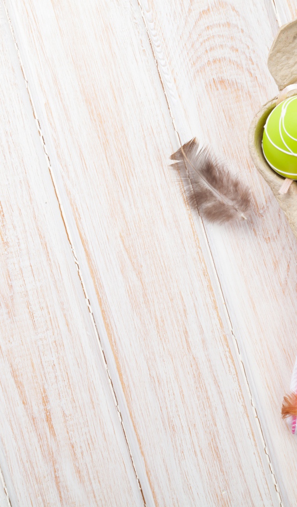 Крашеные пасхальные яйца на столе с тюльпанами