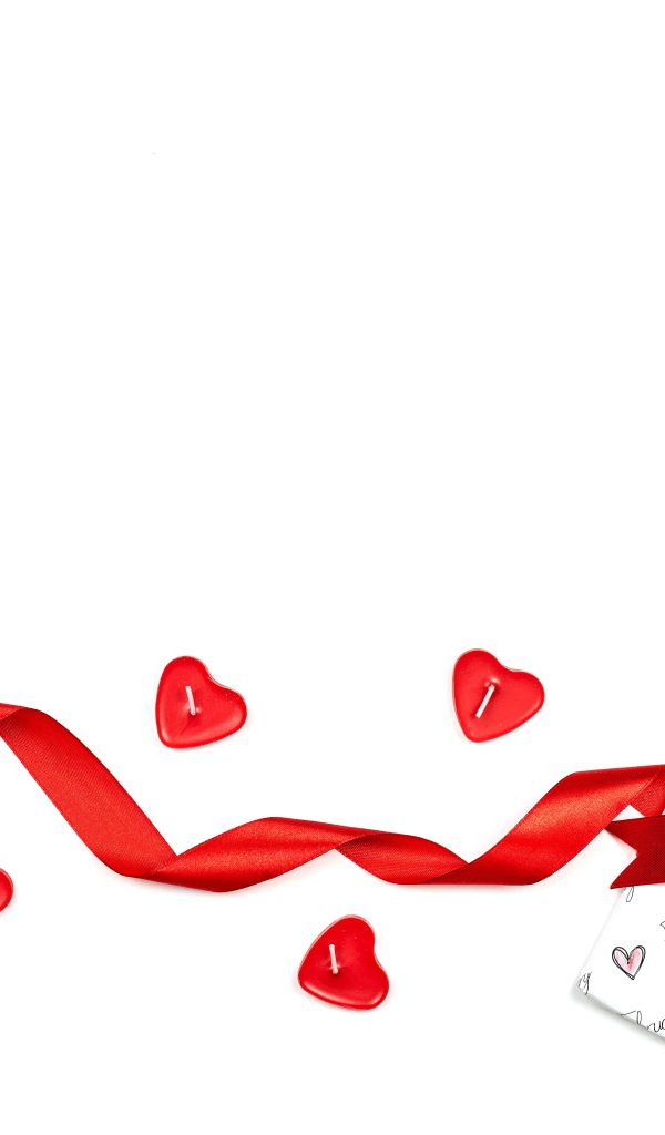 Подарок с красной лентой и свечами на белом фоне на День Святого Валентина