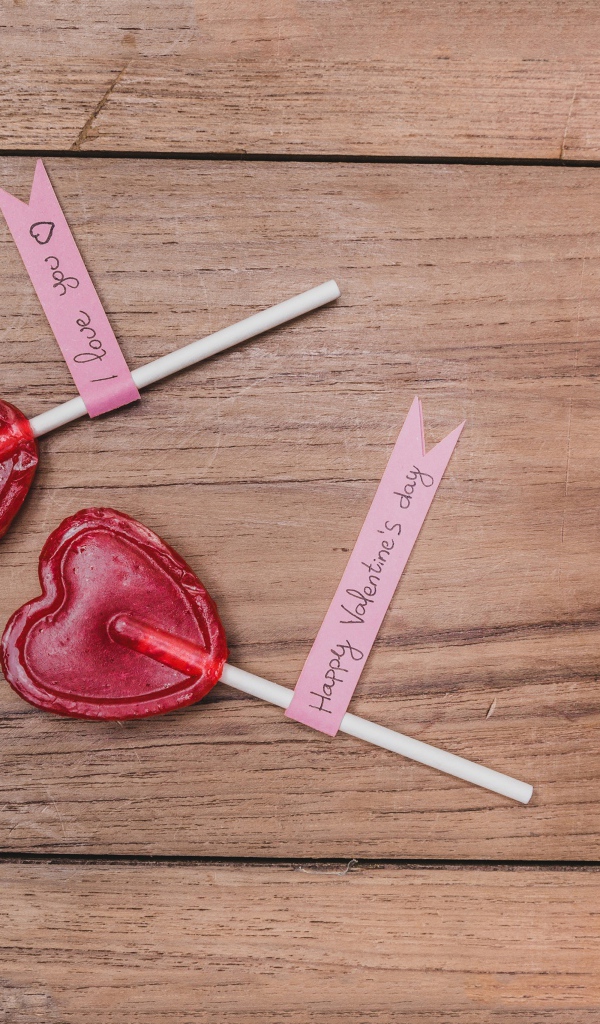 Два красных леденца для любимой на деревянном столе