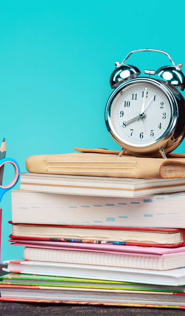 Будильник, книги и канцелярские предметы для школы