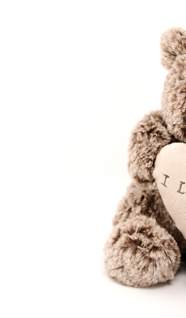 Меховая игрушка медвежонок с сердцем на белом фоне