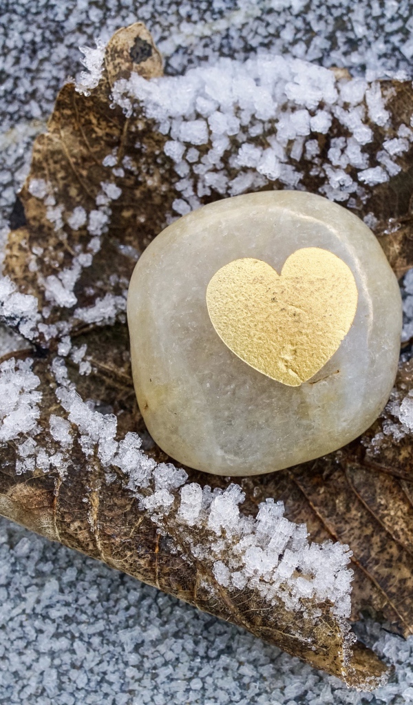 Сердце в камне на заснеженной земле