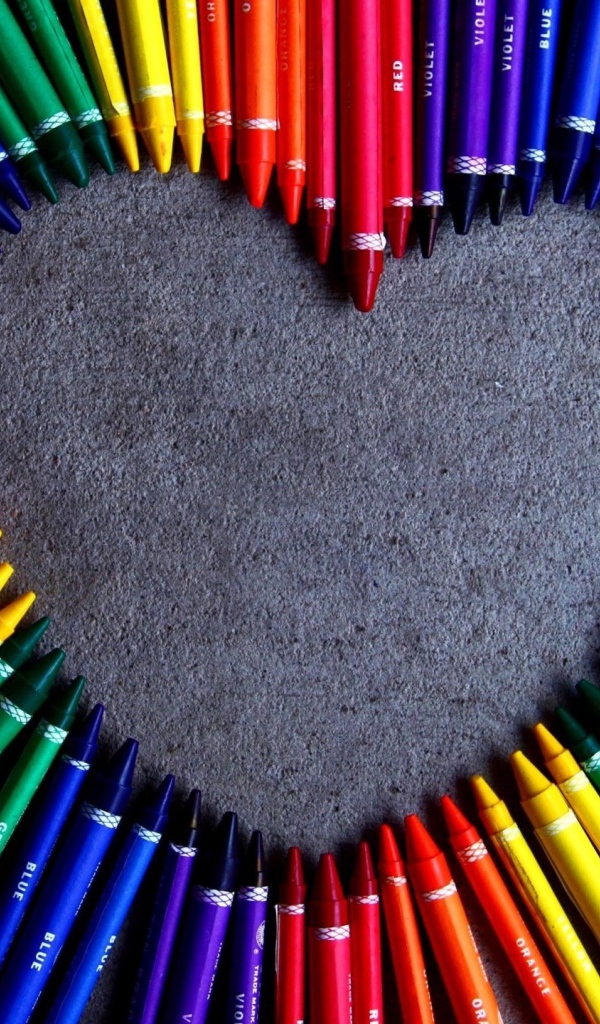 Сердце  из разноцветных карандаш на сером фоне 