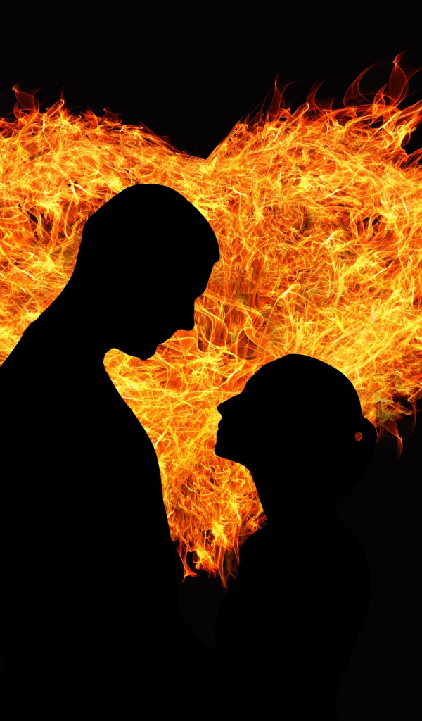 Loving couple on the background of a fiery heart on a black background