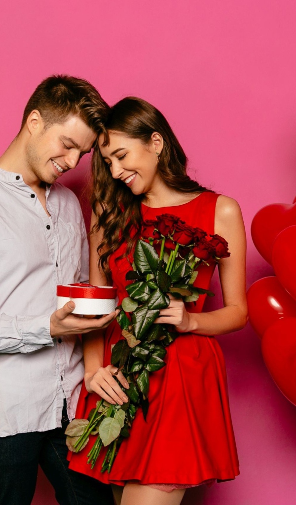 Влюбленная пара с воздушными шариками на розовом фоне 