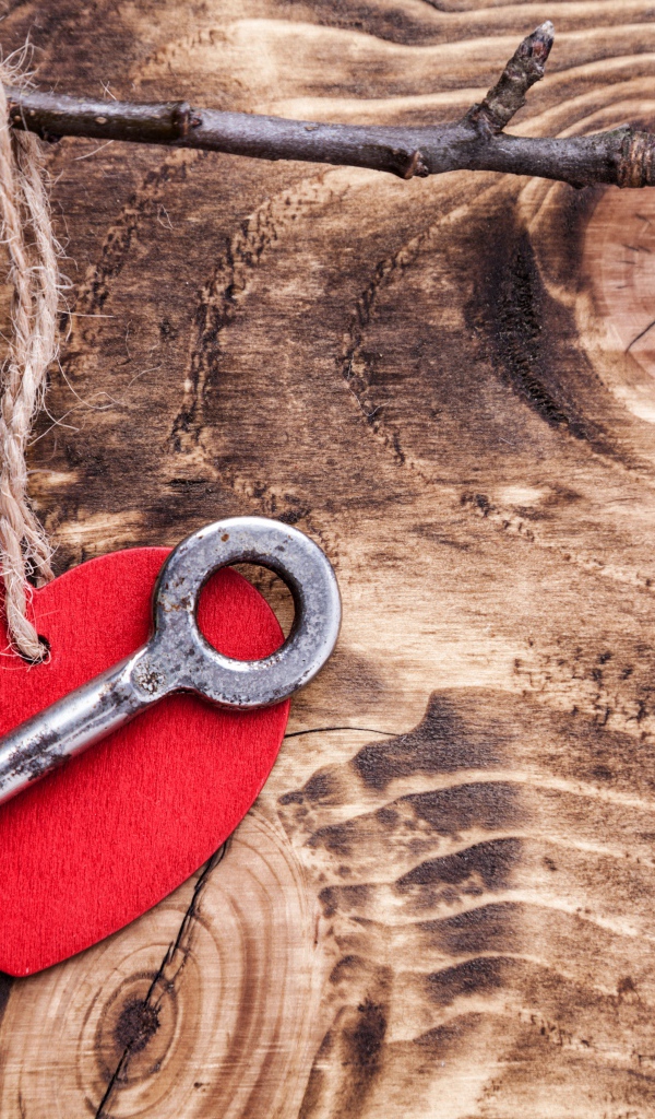 Красное сердечко и ключ на деревянном столе