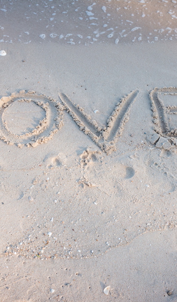 Надпись Любовь на мокром песке у моря