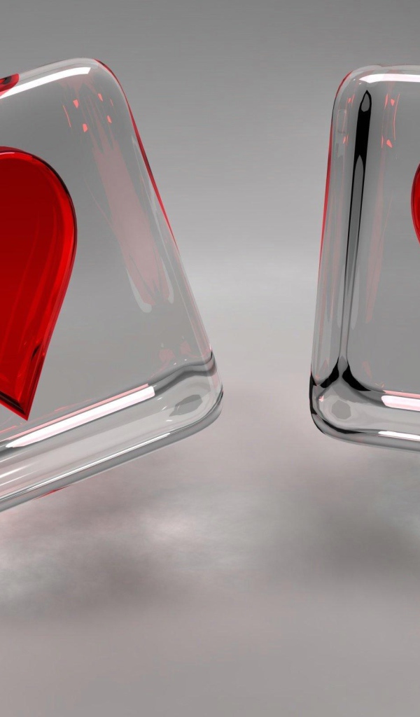 Два стеклянных кубика с сердечками на сером фоне
