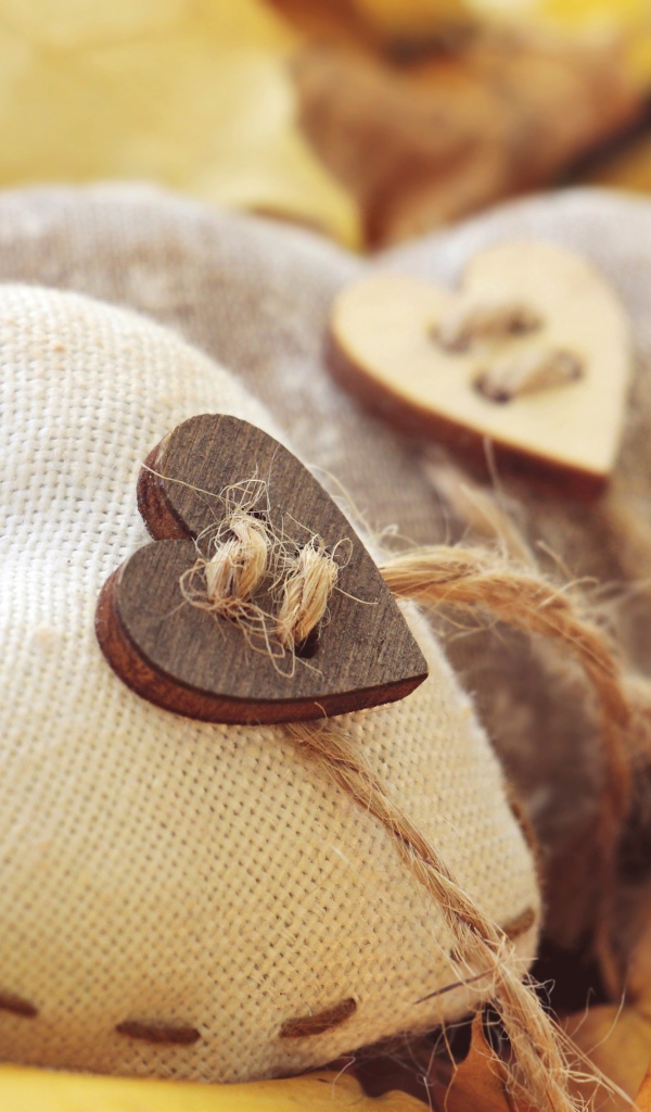 Два сердца из ткани лежит на земле с листьями 