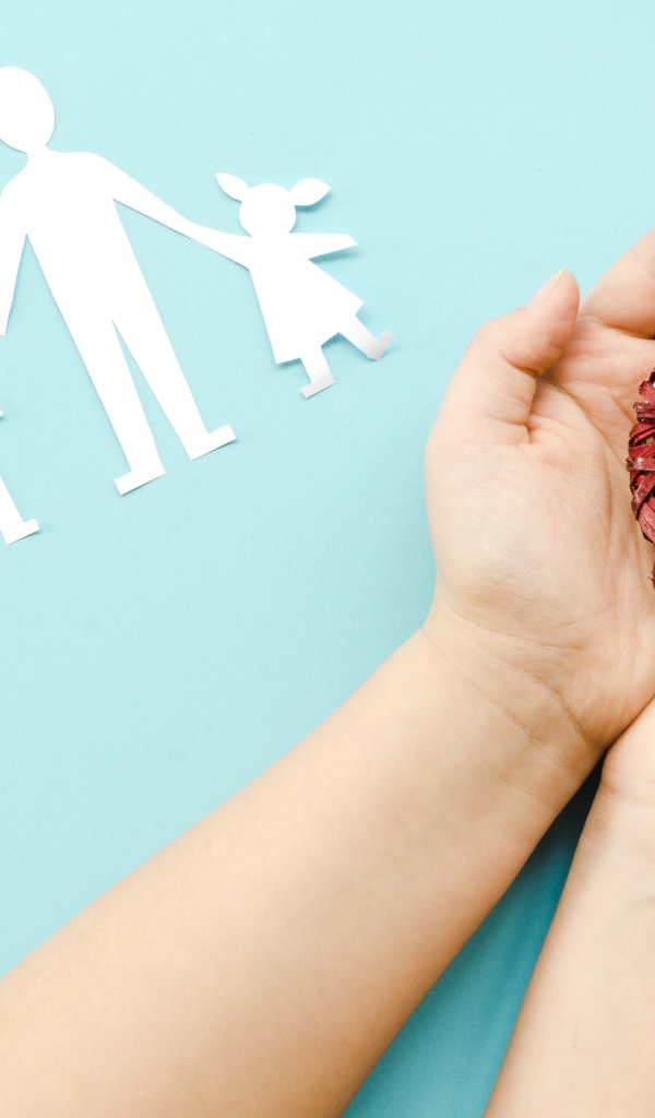 Плетеное сердце в руках на голубом фоне