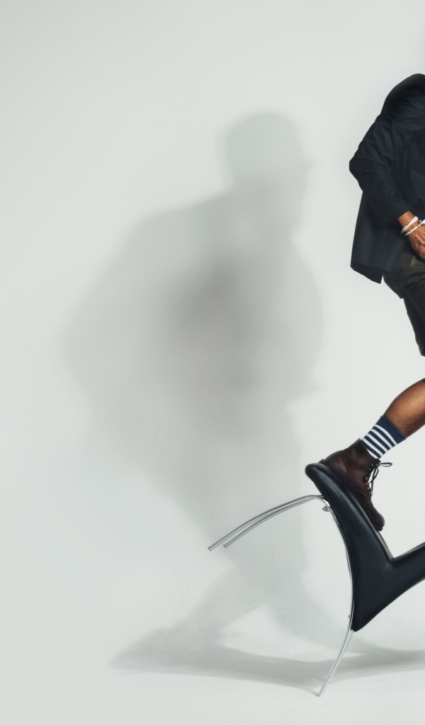 Мужчина балансирует на черном кресле