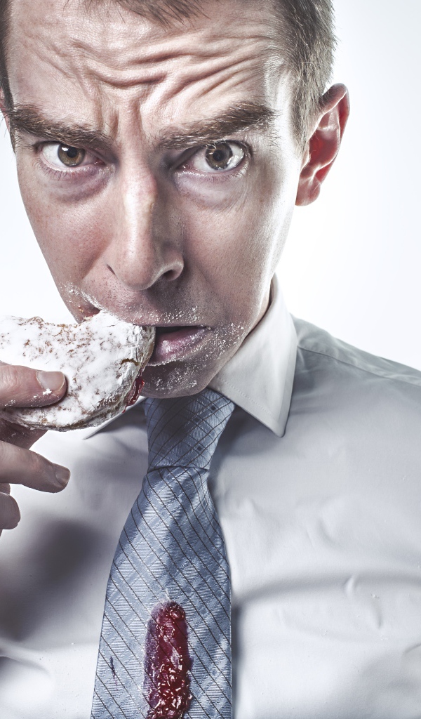 Мужчина в рубашке грызет пряник