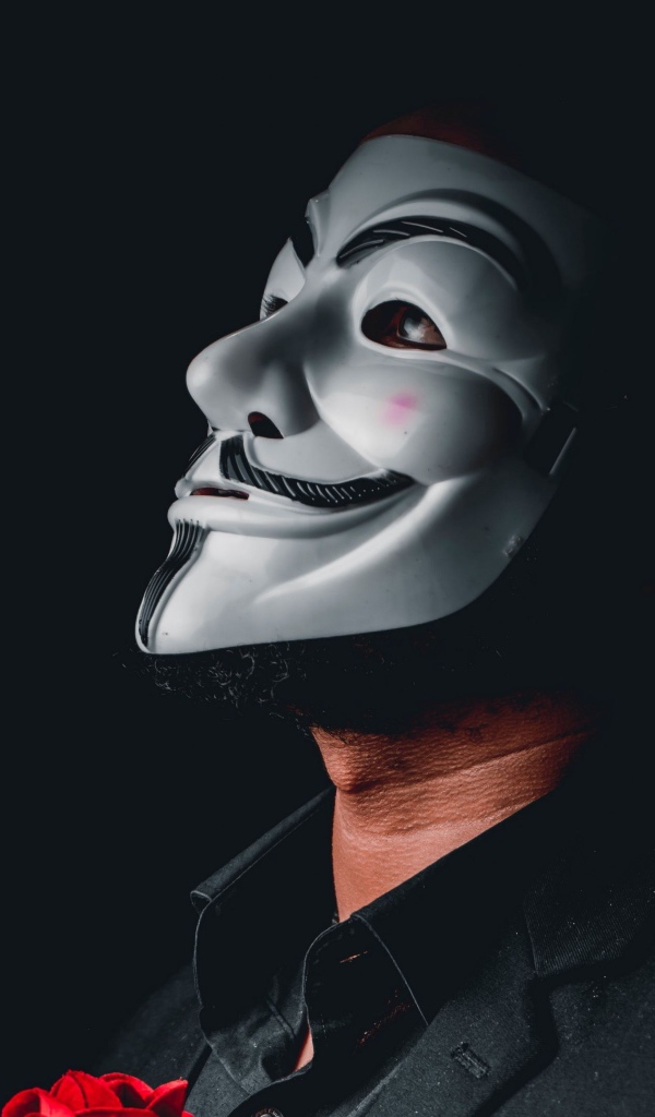 Мужчина в белой маске анонимуса на черном фоне 