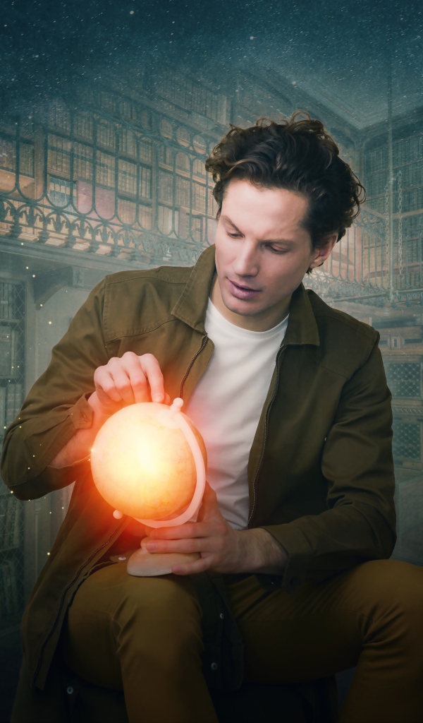 Мужчина в старой библиотеке со светящимся глобусом в руке 