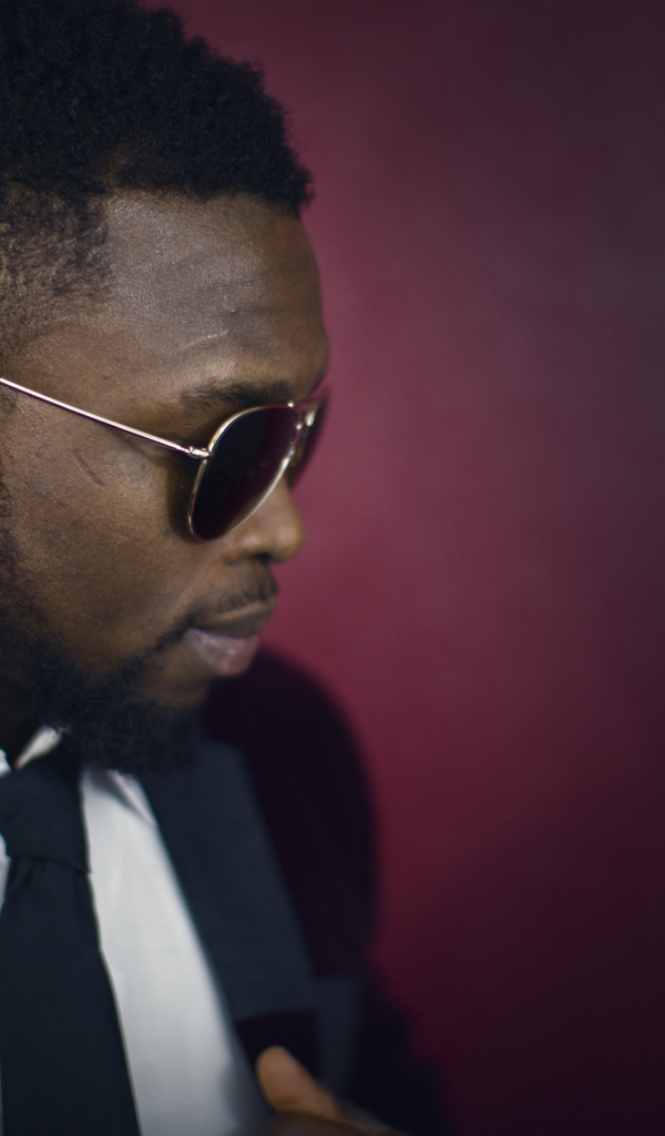 Темнокожий мужчина в костюме и очках 