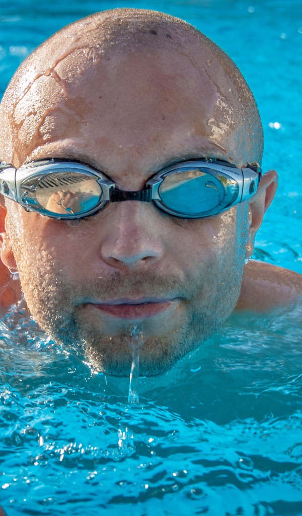 Мужчина пловец в очках в бассейне 
