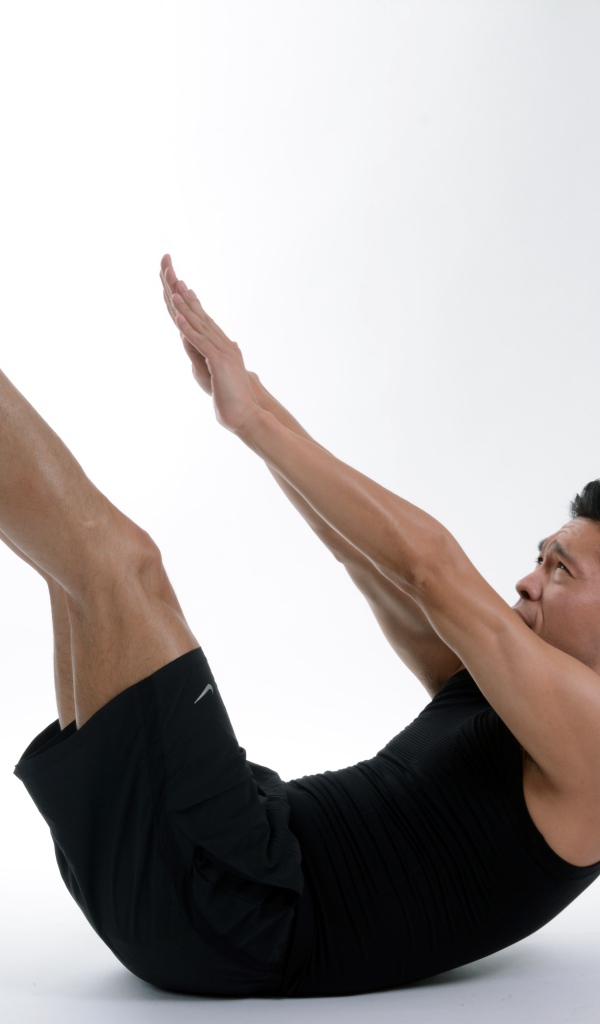 Мужчина спортсмен качает пресс на белом фоне