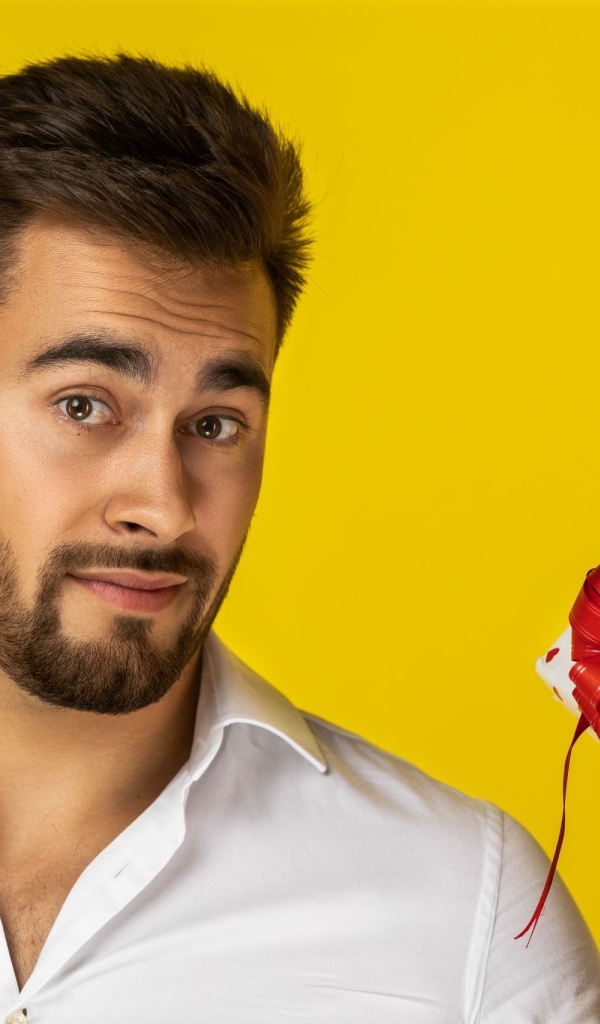 Мужчина с подарком на желтом фоне 