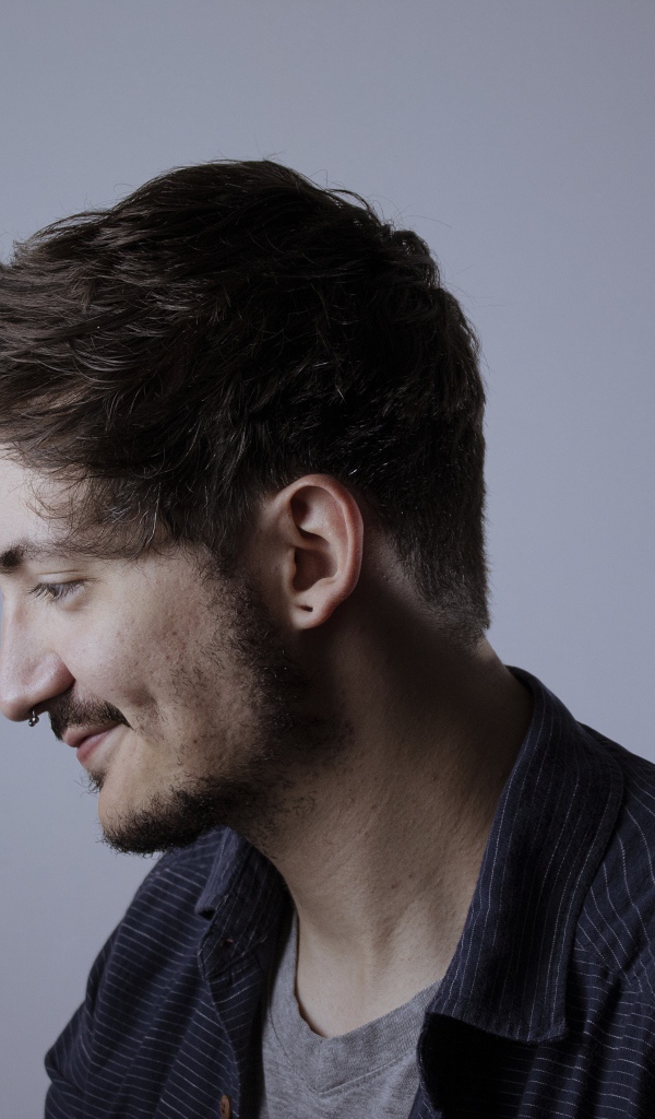 Мужчина с телефоном в руке на сером фоне 