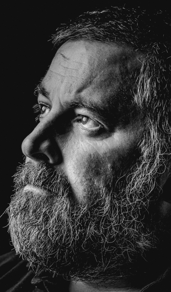 Мужчина с седой бородой на черном фоне 