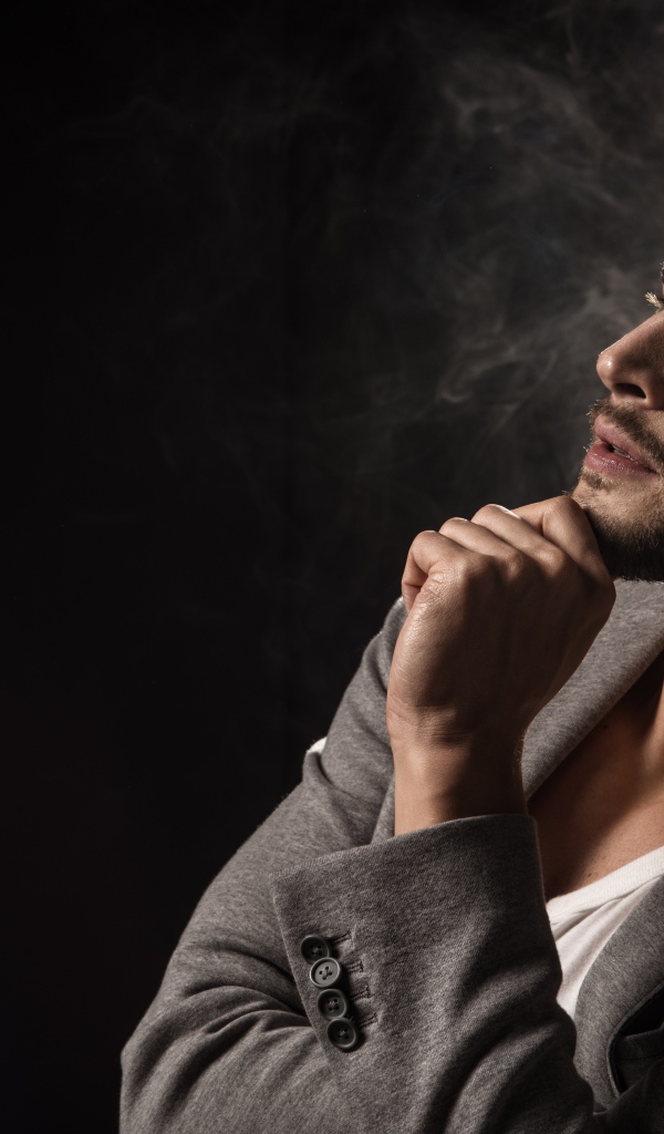 Задумчивый взгляд мужчины на черном фоне 