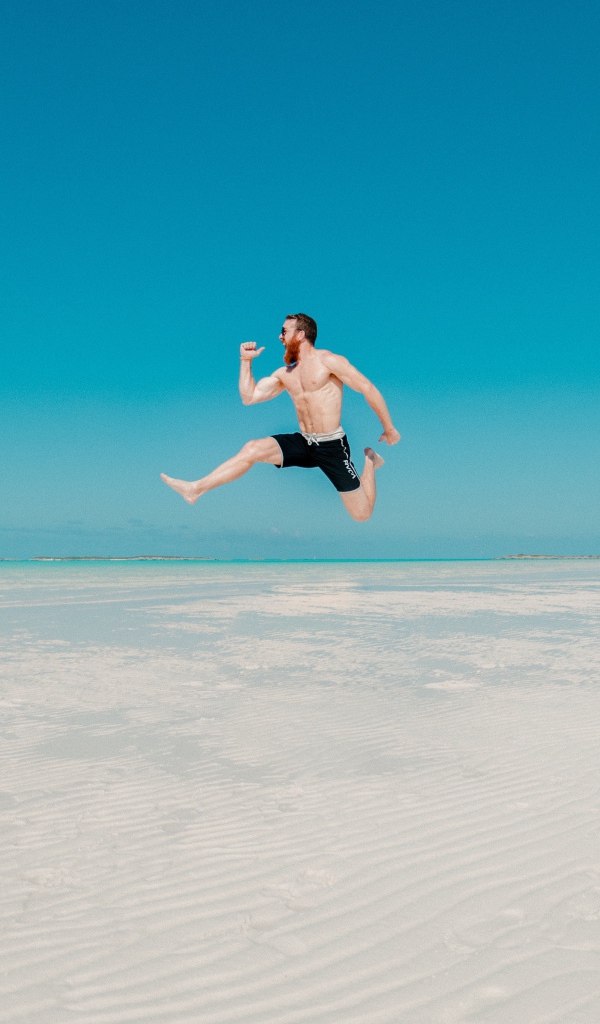 Довольный мужчина прыгает в воде на голубом фоне 