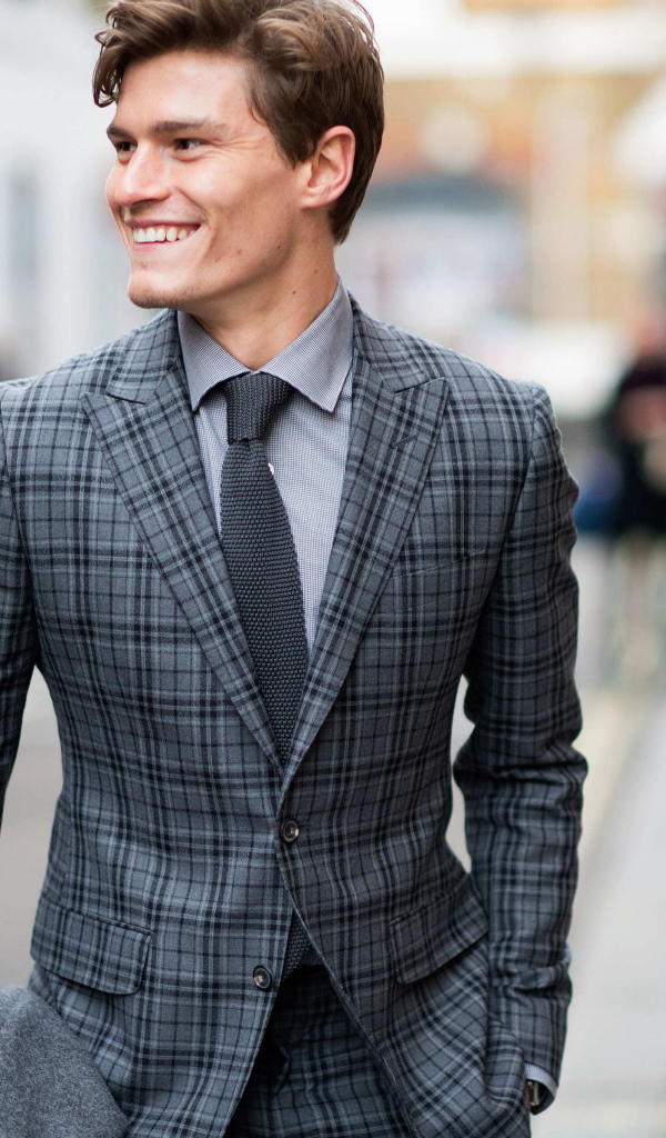 Улыбающийся молодой мужчина в костюме 