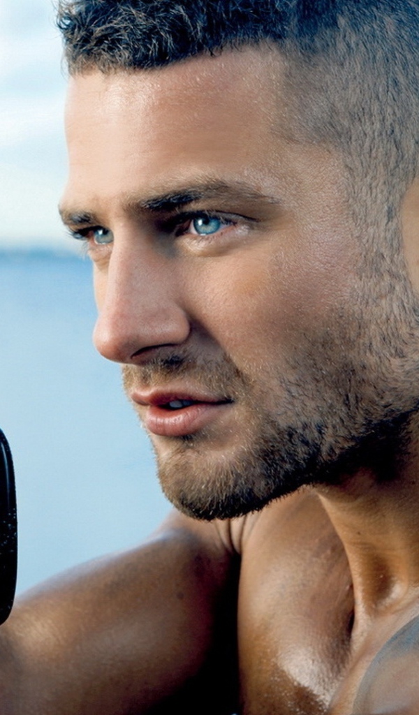 Сильный голубоглазый мужчина с винтовкой в руках 