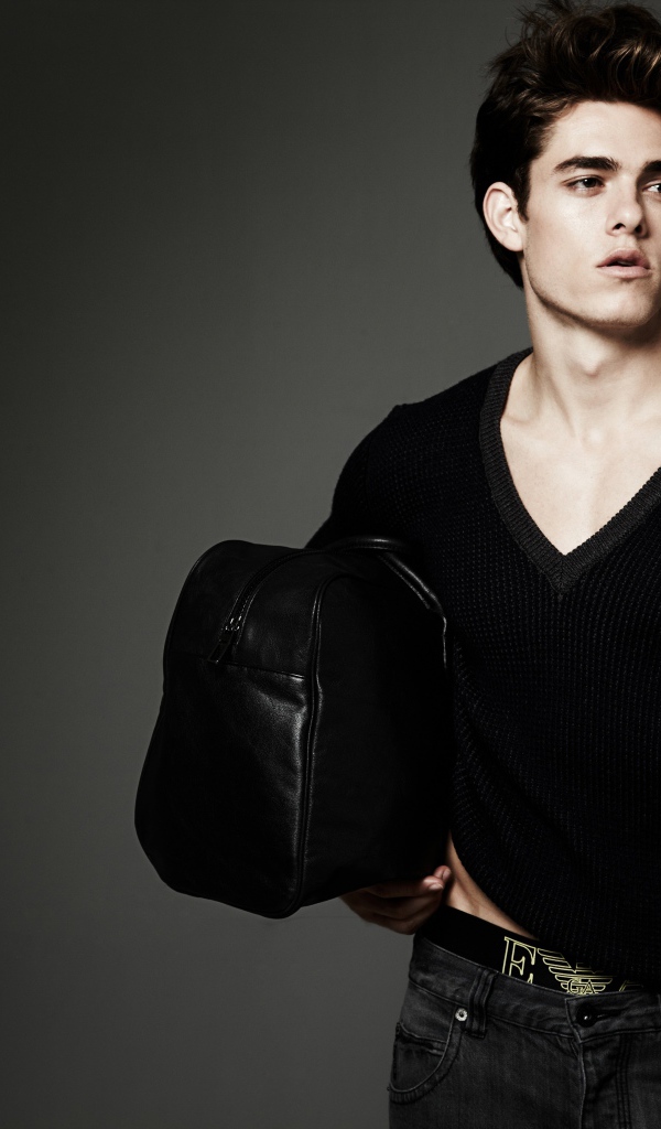 Молодой мужчина с черной сумкой в руке 