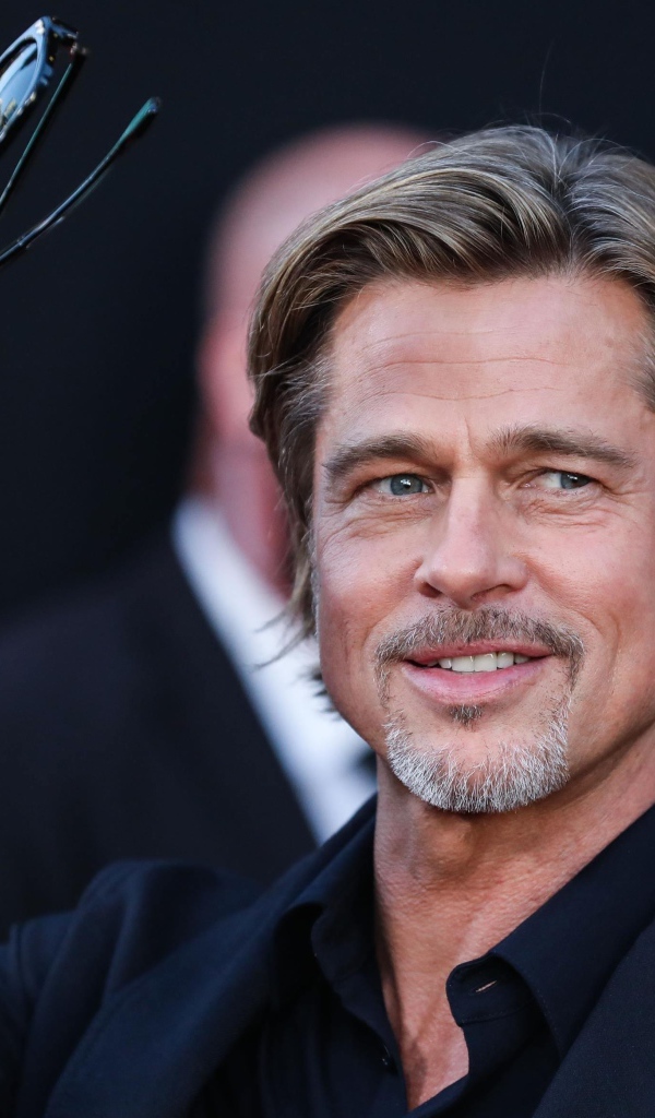 Актер Брэд Питт с очками в руке