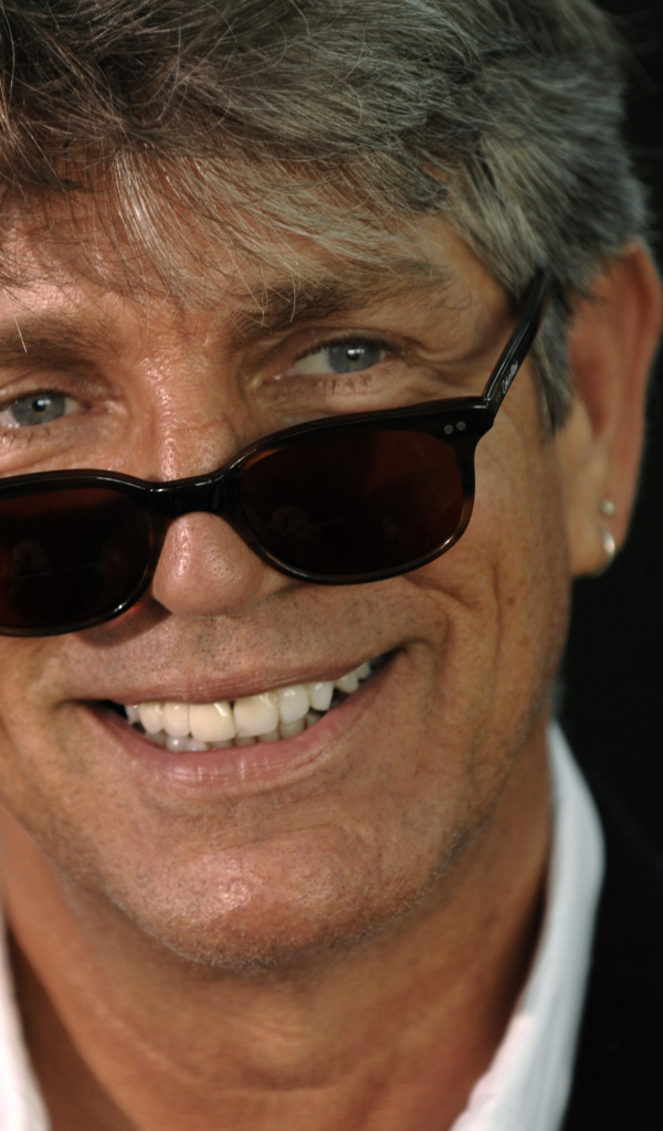 Актер Эрик Робертс в очках на черном фоне