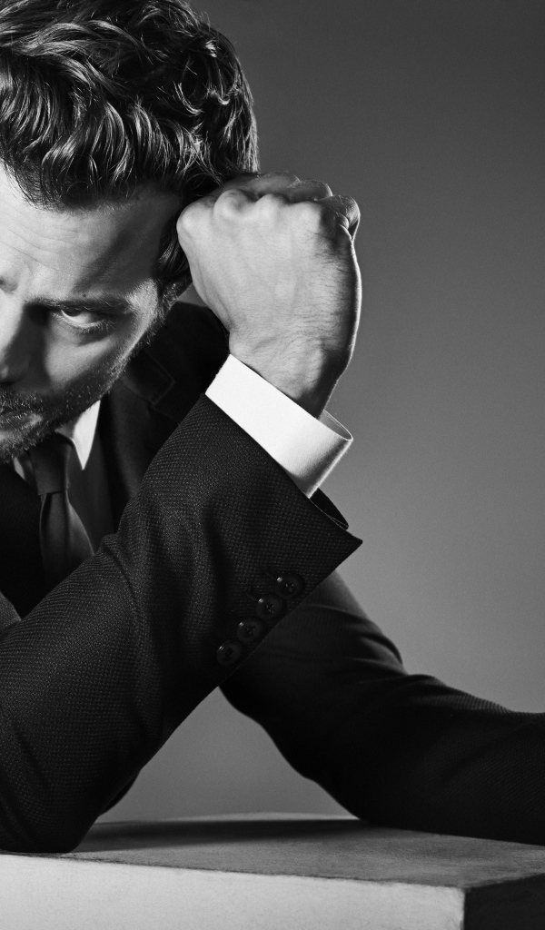 Британский актер Джейми Дорнан на сером фоне