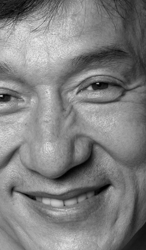 Лицо актера Джеки Чана на черном фоне