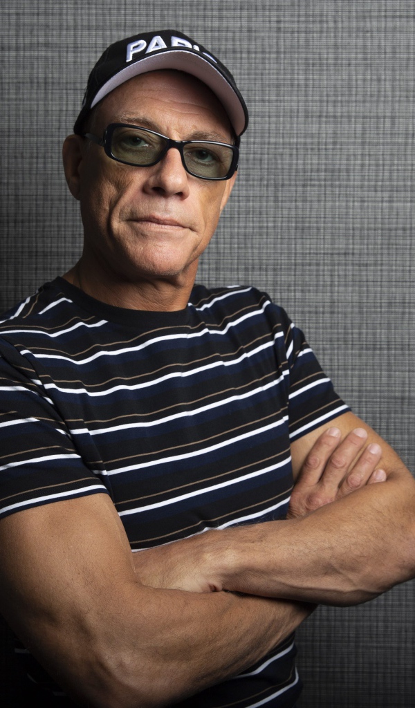 Популярный актер Жан-Клод Ван Дамм в кепке у стены