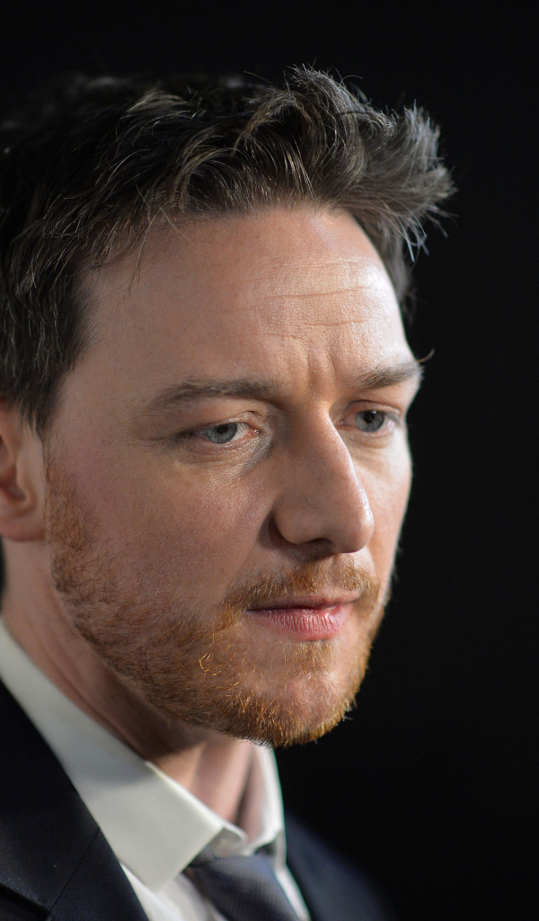 Грустный актер Джеймс МакЭвой на черном фоне