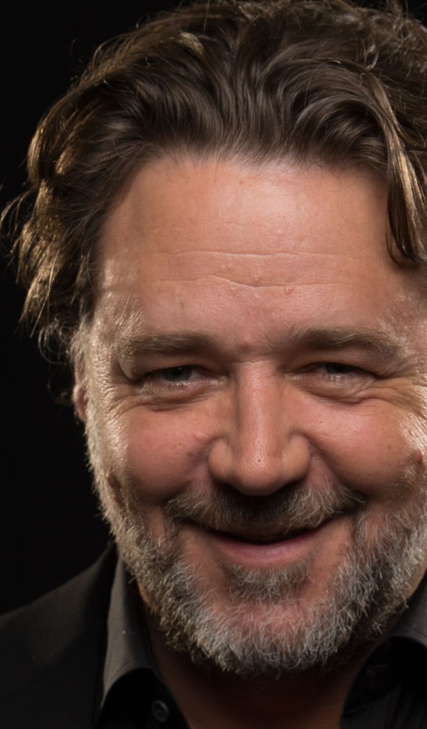 Улыбающийся Рассел Кроу на черном фоне