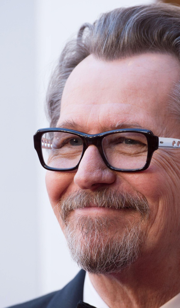 Улыбающийся мужчина, актер Гари Олдман в очках