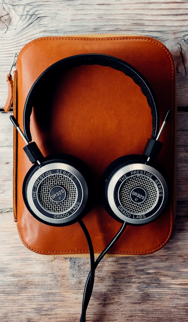 Наушники и плеер в чехле на деревянном столе