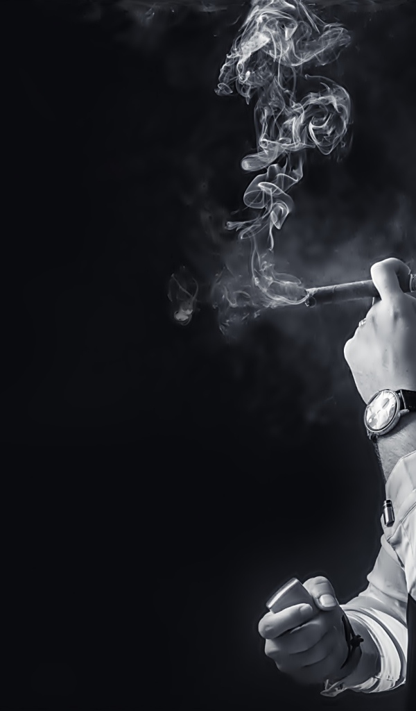 Мужчина с сигарой в руке на черном фоне 