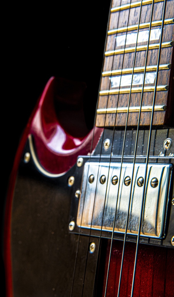 Красная гитара со струнами на черном фоне 