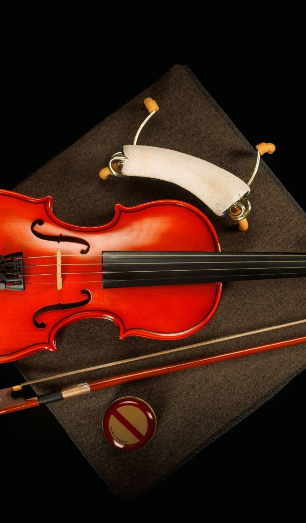 Красная скрипка со смычком на черном фоне