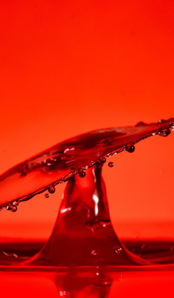 Брызги воды на красном фоне