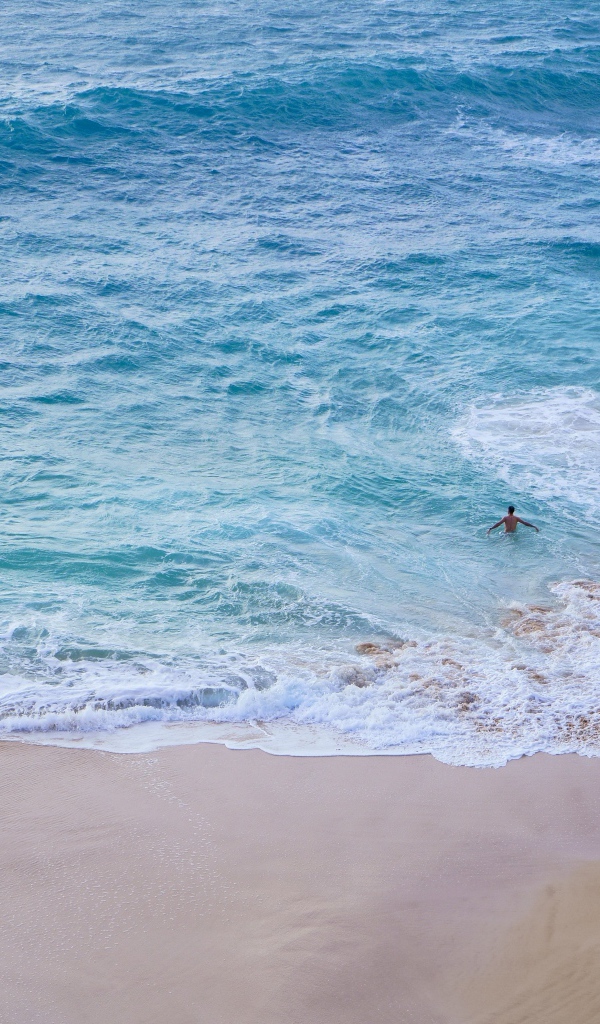 Чистый пляж с белыми морскими волнами на песке
