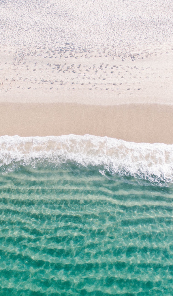 Белый морской песок на берегу у голубой воды